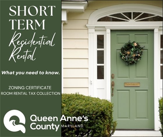 green door on a white house with a wreath