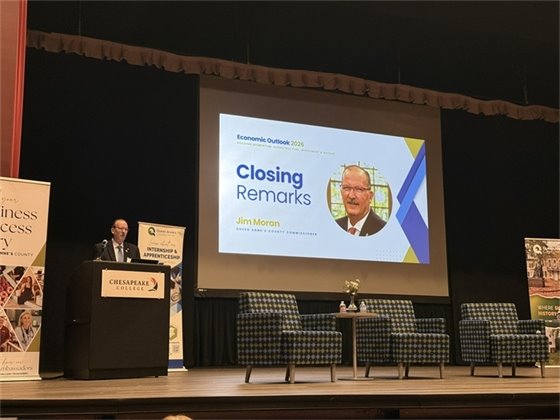 man standing on stage behind a podium