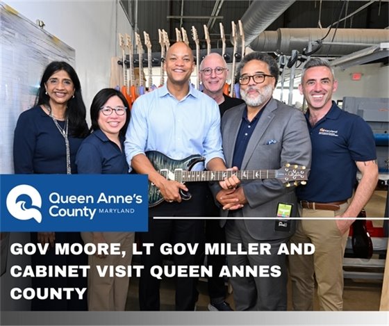 government officials posing at PRS Factory holding a guitar